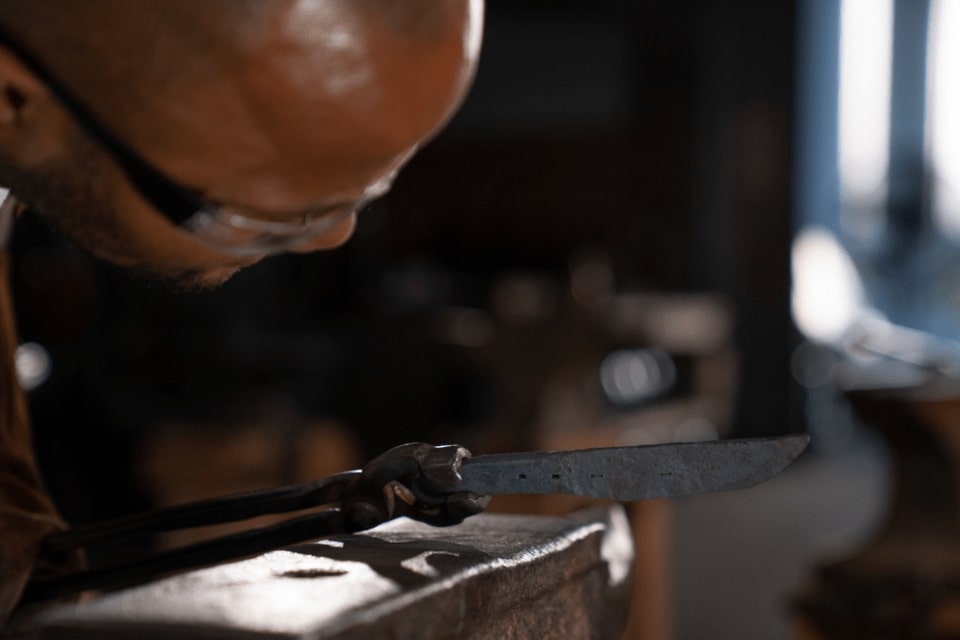 Student inspecting hand forged piece
